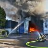 Feuerwehrleute löschen den Brand einer Halle und mehrerer Silos auf einem Firmengelände. Weil die Polizei eine politisch motivierte Brandstiftung im Kontext des Krieges zwischen Israel und dem Iran nicht ausschließt, ermittelt auch der Staatsschutz.