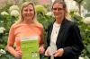 Julia Weimert (links) und Antonia Mach von der Stabsstelle Nachhaltigkeit des Uniklinikums Würzburg präsentieren die Urkunde und die Trophäe des Klimaretter-Awards 2025.