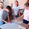 Die Schülerinnen und Schüler nehmen die Geräte entgegen.