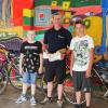 Zwei Schüler bedanken sich bei Heiko Kippes für den Fahrradcheck mit einem selbst gebackenen Brot.