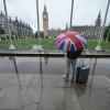 Wetter in Großbritannien: Ein Passant trägt einen Regenschirm auf dem Parliament Square in Westminster im Zentrum Londons.