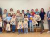 Große Freude bei den Kleinen: Vorstand Rainer Geis (links) überreicht persönlich Einschulungsgeschenke im Kindergarten Regenbogen.