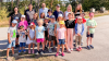 Die Kinder und das Steinbach-Team vor den unternehmenseigenen Bienenstöcken.