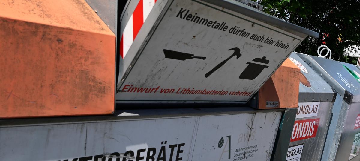 Männer bedienen sich in Wertstoffcontainern