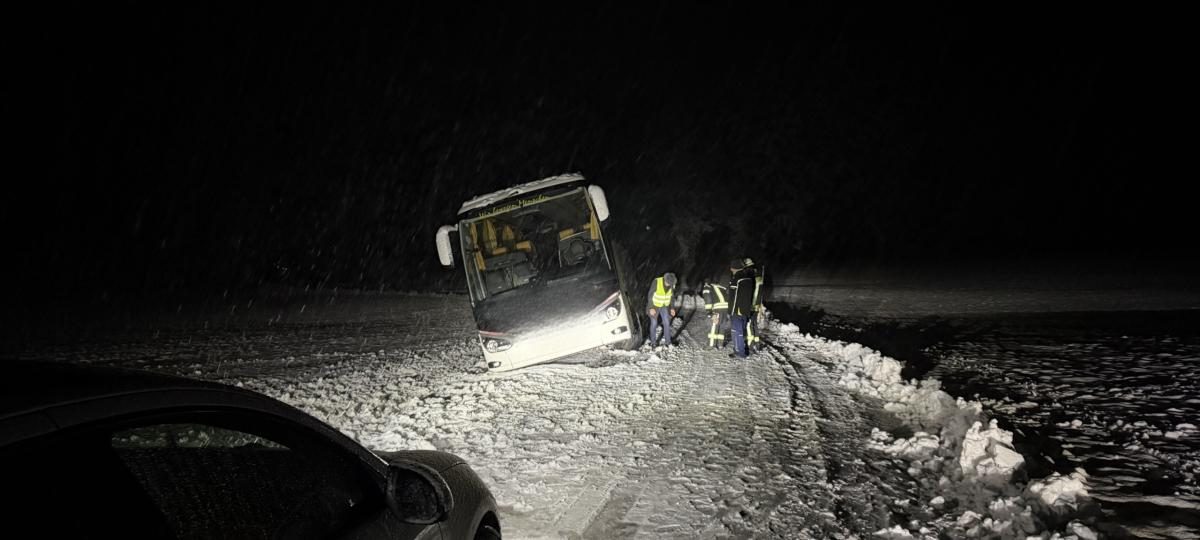 Reisebus kommt bei Dießen von der schneebedeckten Straße ab