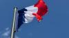 Die Frankreich-Flagge, auch Trikolore genannt, weht in der Pariser Innenstadt vor blauem Himmel.