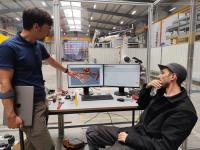Wie ein Holzgitter sieht die Wand aus, die der von Professor Christopher Robeller (links) und seinem Team, hier mit Doktorand Karl Ahlund (rechts), entwickelte Roboter selbstständig baut.