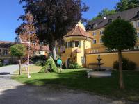 Der gepflegte, romantische Innenhof des Heilbades Krumbad mit dem Gärtner Vitus Freymüller bei der Arbeit.