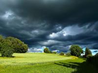 Dunkle Wolken über einem leuchtend grünen Feld bieten zwischen Jedelhausen und Reutti einen faszinierenden Anblick.
