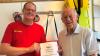 Matthias Tegeler und Erich Pfleiderer mit Urkunde und Ehrennadel für 75 Jahre DLRG.
