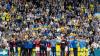 Dänische und ukrainische Spieler versammeln sich nach dem Zusammenbruch des dänischen Spielers Christian Eriksen auf dem Spielfeld.