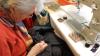 Eine Ehrenamtliche repariert Textilien im Repair Café.