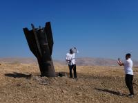 Menschen fotografieren sich neben dem Wrack einer iranischen Rakete, die in der Nähe der Stadt im Westjordanland eingeschlagen ist.