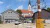 Maibaum, Verwaltungsgebäude und Kirchturm bilden in der Dasinger Ortsmitte eine Sichtachse.
