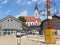 Maibaum, Verwaltungsgebäude und Kirchturm bilden in der Dasinger Ortsmitte eine Sichtachse.