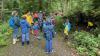 Revierleiter Klaus Wehr (Bildmitte in orange) erklärt den Kindern und Leitern der LBV-Kindergruppen Scheuring, Prittriching und Geltendorf die Bedeutung von Totholz anhand einer umgefallenen 250 Jahre alten Eiche.